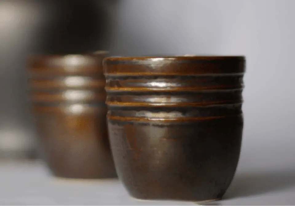Ceramiczne kubeczki w brązowym kolorze ułożone obok siebie wyprodukowane przez FMCeramika